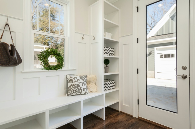 Coin entrée avec banc, coussins et portemanteau pour aménager une entrée ouverte sur salon