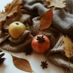 Composition d'automne avec pommes, feuilles mortes et pomme de pin, idée de déco automne à faire soi-même