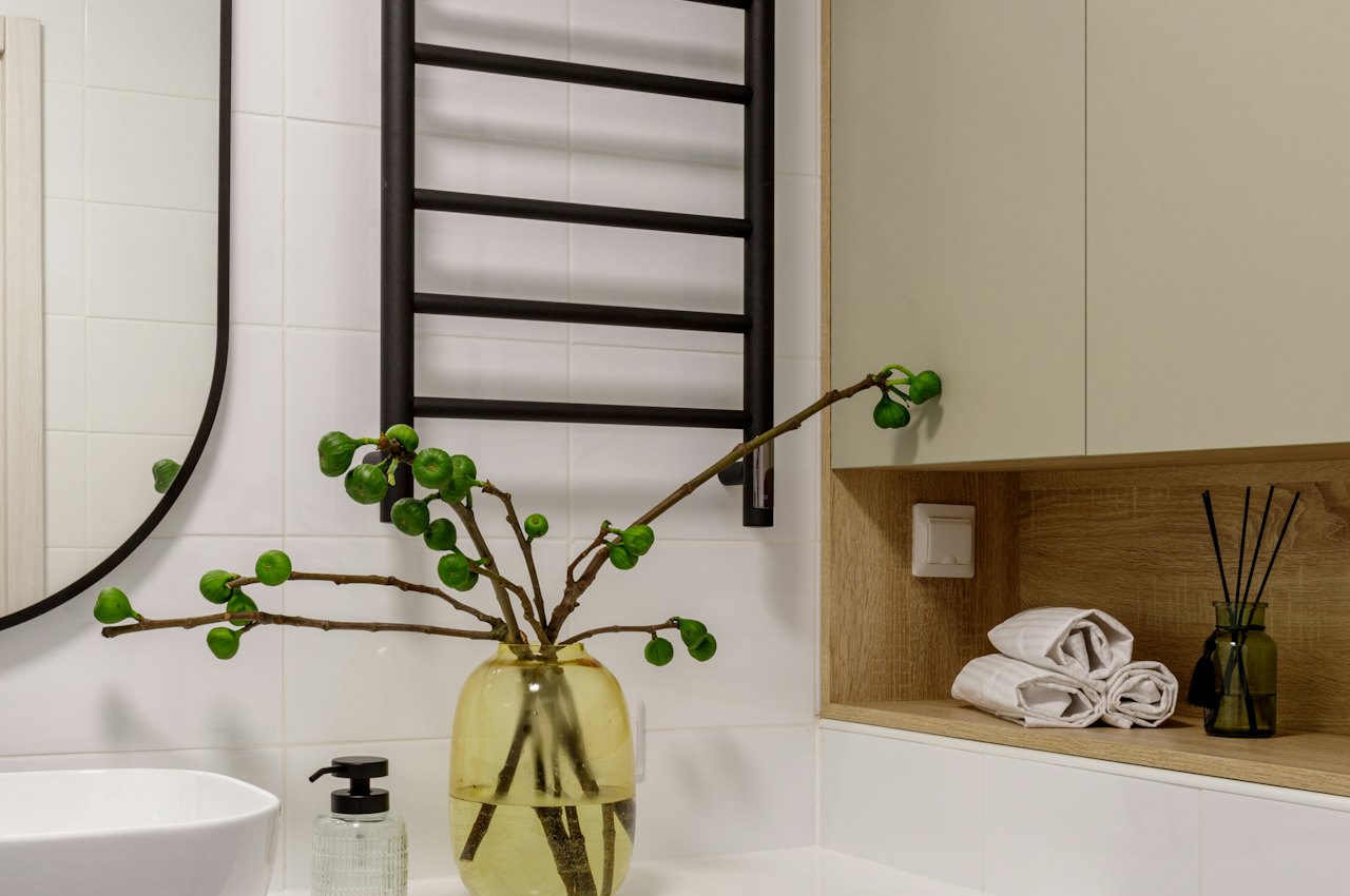 Petite salle de bain avec machine à laver installée près d'une vasque et d'un plan de rangement