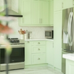 Cuisine moderne aux façades vert clair, exemple de résultat pour relooker un meuble de cuisine avec de l'adhésif