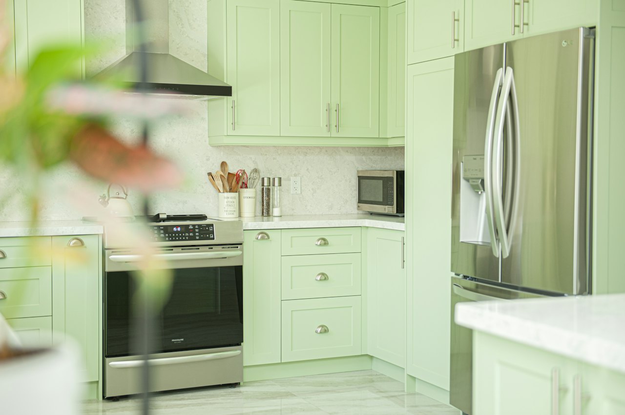 Cuisine moderne aux façades vert clair, exemple de résultat pour relooker un meuble de cuisine avec de l'adhésif
