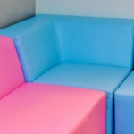 Canapé d'angle modulable installé dans le coin d'un salon, exemple pour choisir un canapé d'angle droit ou gauche