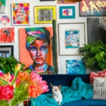 Salon en déco maximaliste avec canapé bleu et mur de cadres colorés