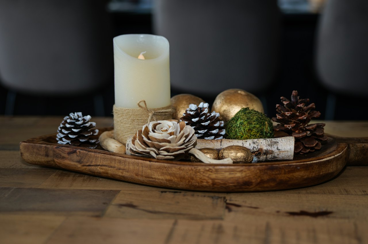 Bougie allumée, pommes de pin et rondins de bouleau dans un plateau en bois, idée de déco de Noël récup nature